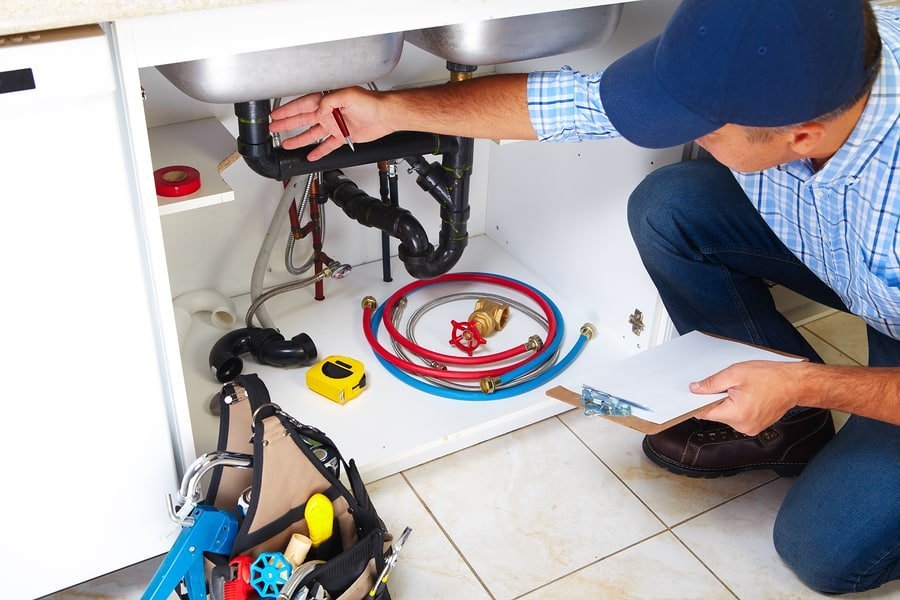 plumber inspecting under sink area